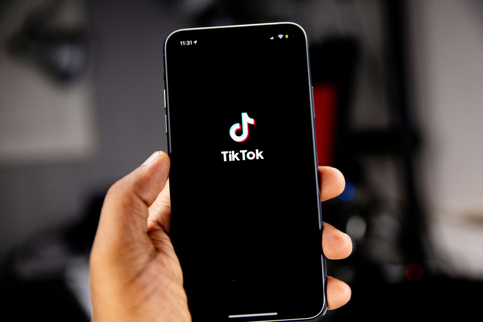 A phone showing a TikTok creator profile, resting on a desk beside a notebook